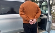 na zdjęciu zatrzymany mężczyzna stoi przy samochodzie
