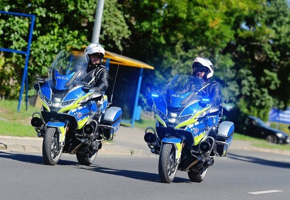 dwóch policjantów jadących obok siebie na motocyklach oznakowanych
