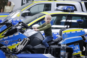 Dziecko siedzi na motocyklu oznakowanym policji.