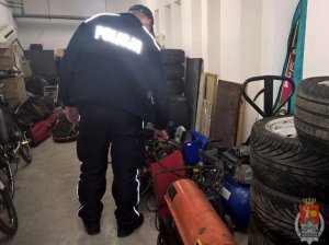 policjant podczas przeszukania garażu