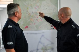 policjanci w sztabie oglądają mapę
