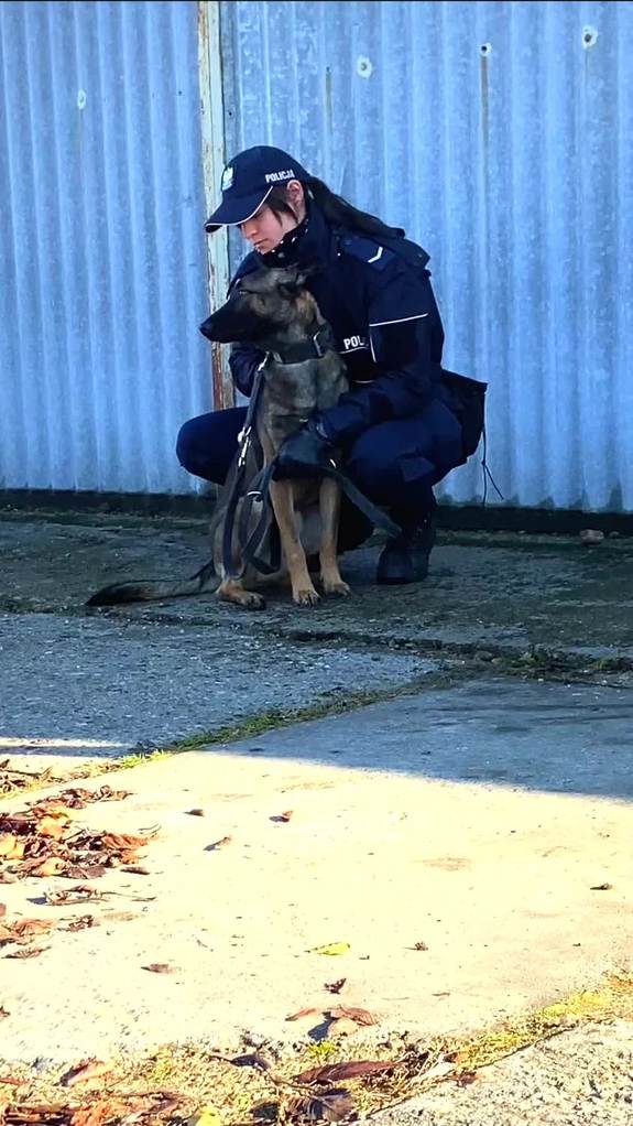 Policjantka głaszcze swojego psa.