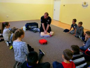 Aspirant Dariusz Brygier - policjant ratownik uczy dzieci pierwszej pomocy medycznej