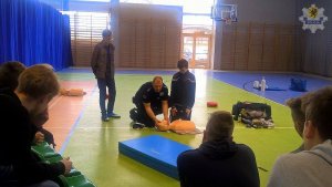 Aspirant Dariusz Brygier - policjant ratownik uczy dzieci pierwszej pomocy medycznej
