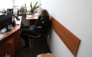 zatrzymana przez policjantów kobieta siedzi na krześle w trakcie przesłuchania