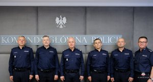 Dwaj policjanci z Buska Zdroju w mundurach z dwoma przełożonymi również w mundurach z Komendantem Głównym Policji i Dyrektorem Gabinetu KGP, w tle napis: Komenda Główna Policji
