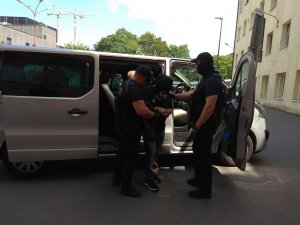 policyjny furgon nieoznakowany, z którego wysiadają policjanci po cywilnemu i podejrzany