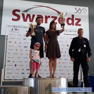 Nadkom. Joanna Woźniak-Cieślar z wrocławskiej Policji na podium  wraz z mężem i dzieckiem