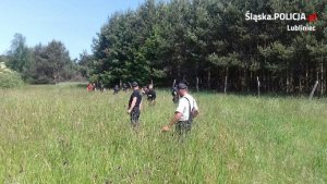 policjanci szukają mężczyzny na łące i w lesie
