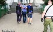 dwaj policjanci prowadzą zatrzymanego