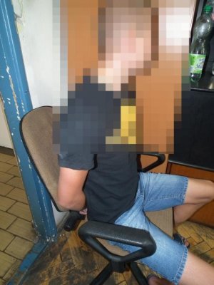 zatrzymany mężczyzna siedzi na krześle, ma założone kajdanki na ręce