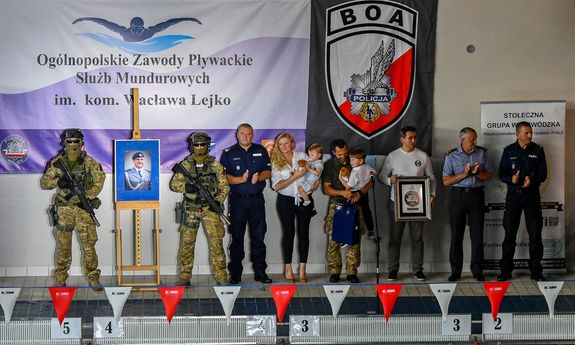 Zdjęcie przedstawia gości zgromadzonych na otwarciu zawodów m.in. Zastępca Komendanta Głównego Kamil Bracha, wdowę po zmarłym Policjancie Annę Lejko  z dziećmi oraz dowódcę BOA Dariusza Ziębę.