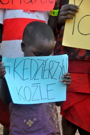 Chłopiec z Tanzanii trzyma w ręce kartkę z napisem in Kędzierzyn-Koźle&quot;&gt;