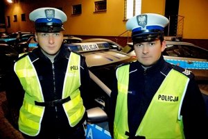 dwaj policjanci przed radiowozem