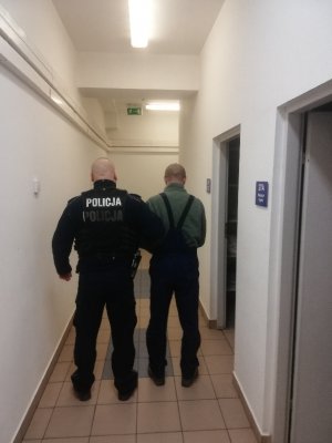 Policjanci wykonują czynności  z zatrzymanym mężczyzną