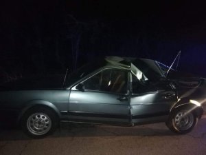 srebrny samochód osobowy  stojący na drodze  z uszkodzona karoserią, pęknięta na pół