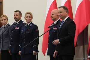 Prezydent Andrzej Duda podczas przemówienia w tle Komendant Główny Policji i Rektor WSPol