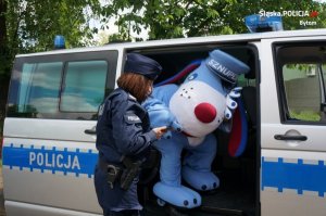 policjantka w mundurze,  Sznupek - maskotka śląskiej Policji i radiowóz