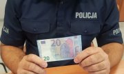 policjant z zabezpieczonymi banknotami