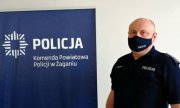 mężczyzna w koszulce z napisem policja, po lewej stronie baner z napisem Komenda Powiatowa Policji w Żaganiu