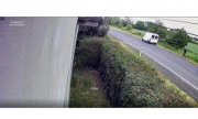 Na zdjęciu widać drogę, na której znajduje się zaparkowany biały bus. Nieopodal biegnie jego kierowca
