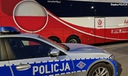 policyjny radiowóz na tle autokaru piłkarskiej reprezentacji Polski