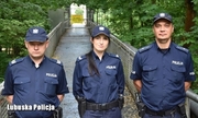 dwaj policjanci i policjantka stoją przed zamkniętym mostem