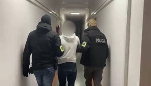 policjanci prowadzą zatrzymanego mężczyznę