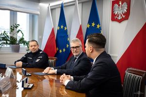 widok z boku na Zastępcę Komendanta Głównego Policji, Prezesa Zarządu JTI Polska i Dyrektora ds. Korporacyjnych i Komunikacji, którzy siedzą za stołem