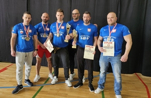 sześciu zawodników pozuje do zdjęcia, na szyjach mają zawieszone medale, w dłoniach trzymają dyplomy