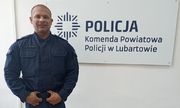 Policjant stoi przy napisie Komenda Powiatowa Policji w Lubartowie