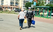 Policjant pomaga kobiecie nieść torby z zakupami