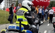 Policjant na motocyklu podczas zabezpieczania Tour de Pologne i kibice oglądający wyścig
