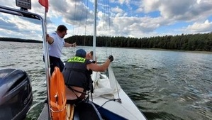 policyjni wodniacy pomagają żeglarzom na łódce