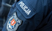na ranieniu munduru policjanta napis policja, poniżej naszywka z logiem Komendy Powiatowej Policji w Leżajsku