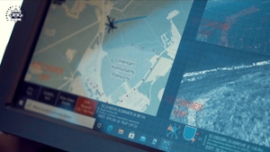 ekran w śmigłowcu przedstawiający mapę z położeniem lecącego śmigłowca i podgląd z kamery