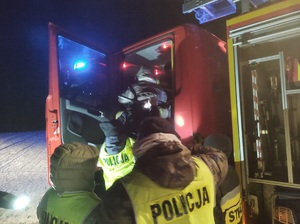 policjanci w trakcie poszukiwań przy wozie strażackiej