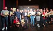 Laureaci nagrody Złotego Serca stoją na scenie i pozują do zdjęcia, pośród nich znajduje się Komendant Powiatowy Policji w Pabianicach inspektor Jarosław Tokarski
