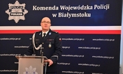 inspektor Kamil Borkowski stoi przy mównicy z mikrofonem, w tle napis Komenda Wojewódzka Policji