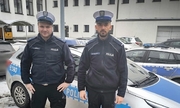 Wspólne zdjęcie dwóch policjantów przy radiowozie