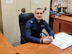 Sierżant Rafał Matyja siedzi za biurkiem