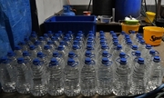 w pomieszczeniu gospodarczym na ziemi stoją 5 litrowe butelki plastikowe wypełnione alkoholem