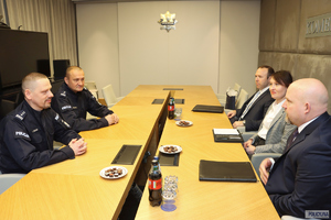 Spotkanie p.o. Komendanta Głównego Policji z agentami FBI. Uczestnicy spotkania siedzą naprzeciwko siebie przy stole.