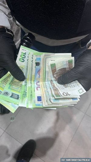 pieniądze trzymane w dłoniach policjanta