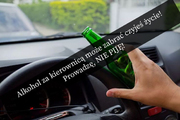 Dłoń z butelką po alkoholu trzymana na kierownicy. W poprzek zdjęcia widnieje napis: Alkohol za kierownicą może zabrać czyjeś życie! Prowadzę, NIE PIJĘ!