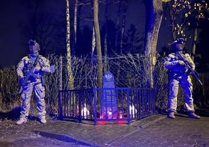 Dwaj funkcjonariusze przy pomniku upamiętniającym policjantów CPKP BOA poległych podczas akcji