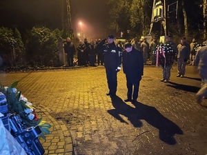minister swia i zastępca komendanta głównego Policji w asyście policjantów trzymających wieńce, w tle inni uczestnicy uroczystości