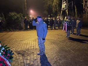 dowódca CPKP BOA w asyście policjantów trzymających wieńce, w tle inni uczestnicy uroczystości
