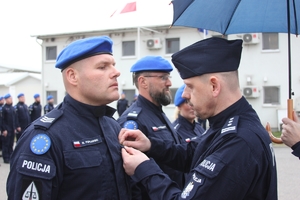 Pełniący obowiązki Komendant Główny Policji insp. Marek Boroń przypina medal funkcjonariuszowi JSPP