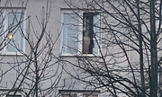 Na zdjęciu dziecko stoi na parapecie i wychyla się przez okno
